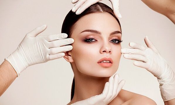 Hands in gloves at the face of the girl