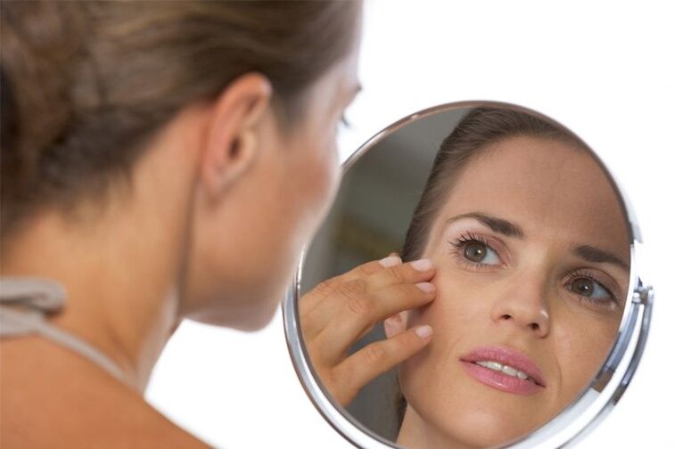 A girl looks in the mirror before skin rejuvenation